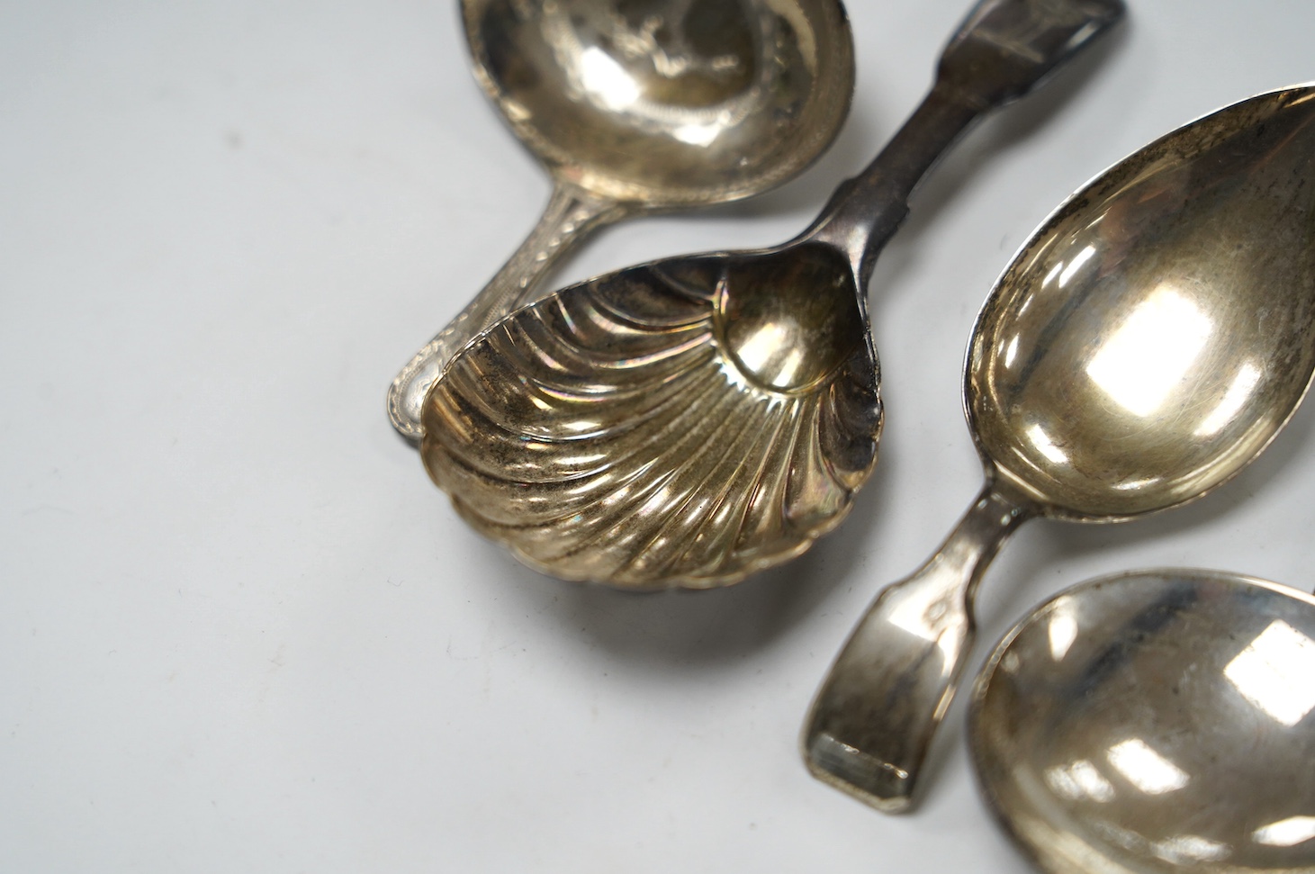 Five assorted silver caddy spoons, including shovel bowl by Cocks & Bettridge, Birmingham, 1810, 61mm, leaf bowl by William Pugh, Birmingham, 1814, Eley & Fearn, London, 1804, bright cut engraved bowl, George Baskerville
